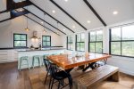 Beautiful dining room and table with seating for many looking into the kitchen